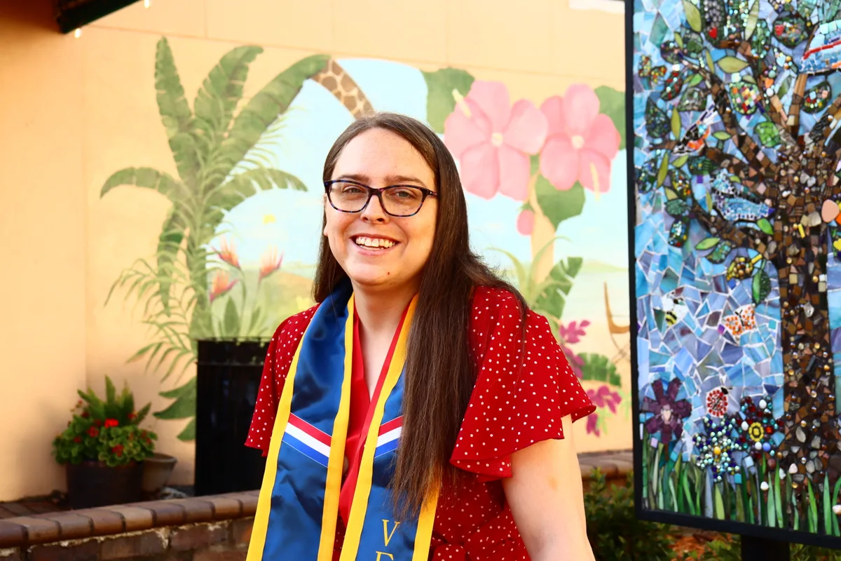 Tessa Rouse smiling in academic regalia
